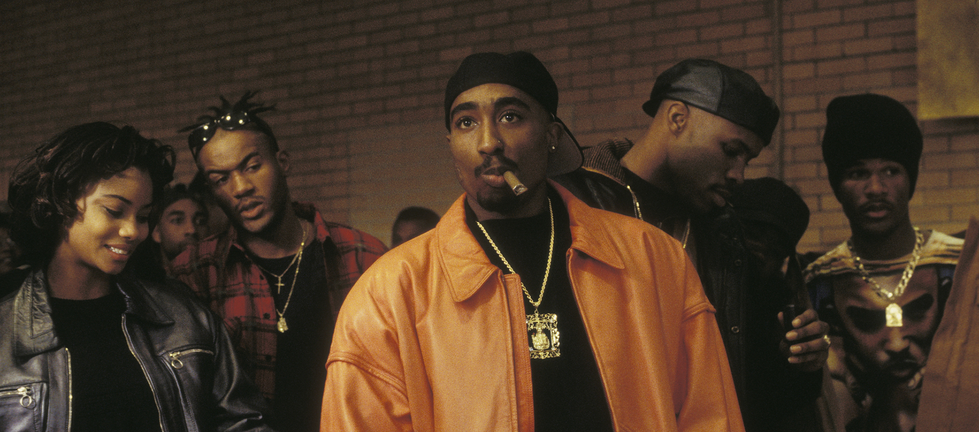Image of Tupac as Birdie in Above the Rim, standing in a group of people.