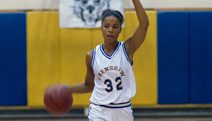 Still from Love & Basketball of a woman dribbling a basketball wearing a basketball uniform.