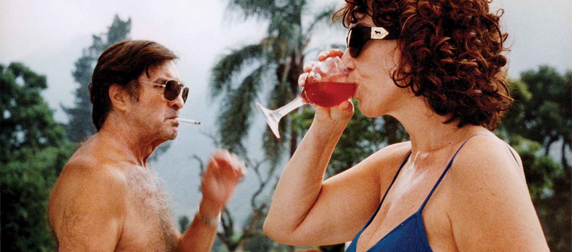 a woman drinking a red drink, a shirtless man with a cigaratte in his mouth