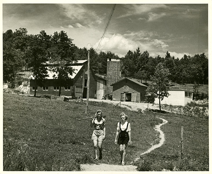 archival photo of two women walking in a rural landscape