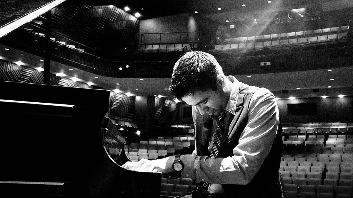 Black and white photo of musician playing piano