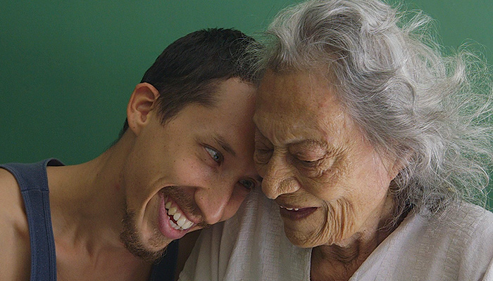 Grandson leans head on grandmother's shoulder