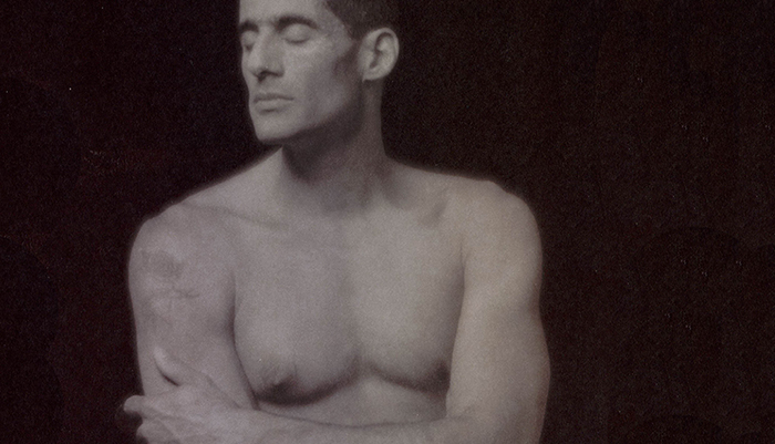 A shirtless man with his eyes closed.