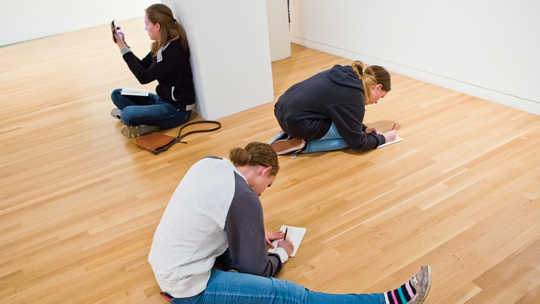 three woman on the wexner galleries floor, noting things down