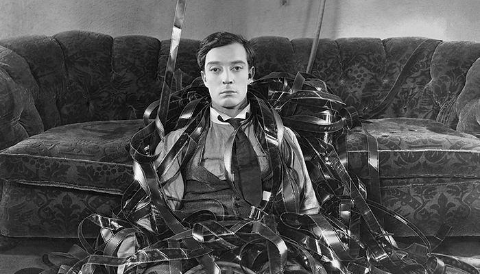 Buster Keaton surrounded by film in a still from the classic comedy Sherlock Jr.