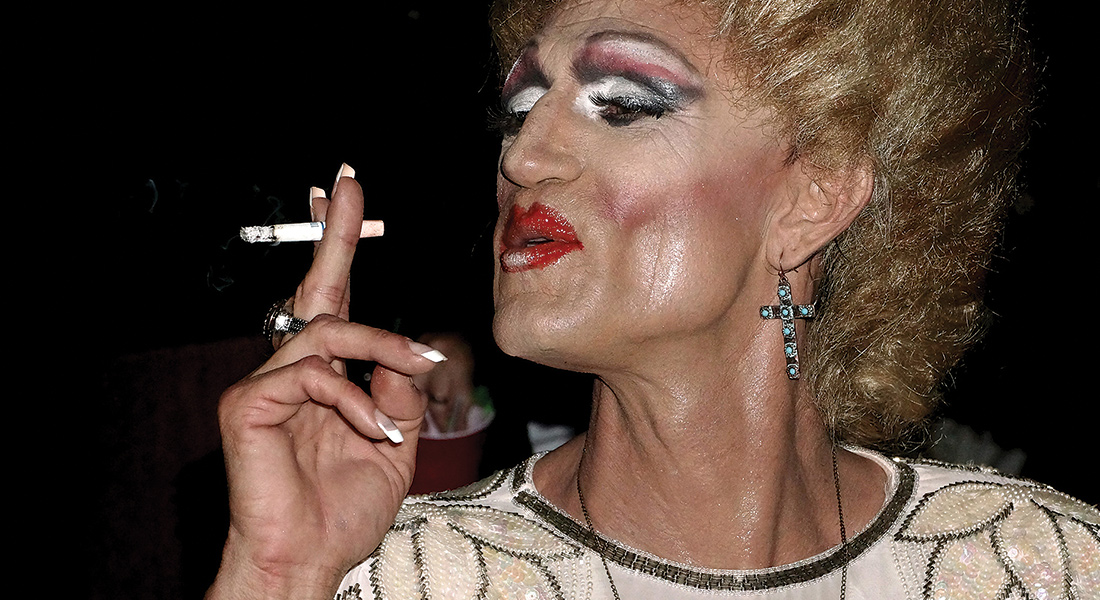 Woman in full makeup smoking a cigarette