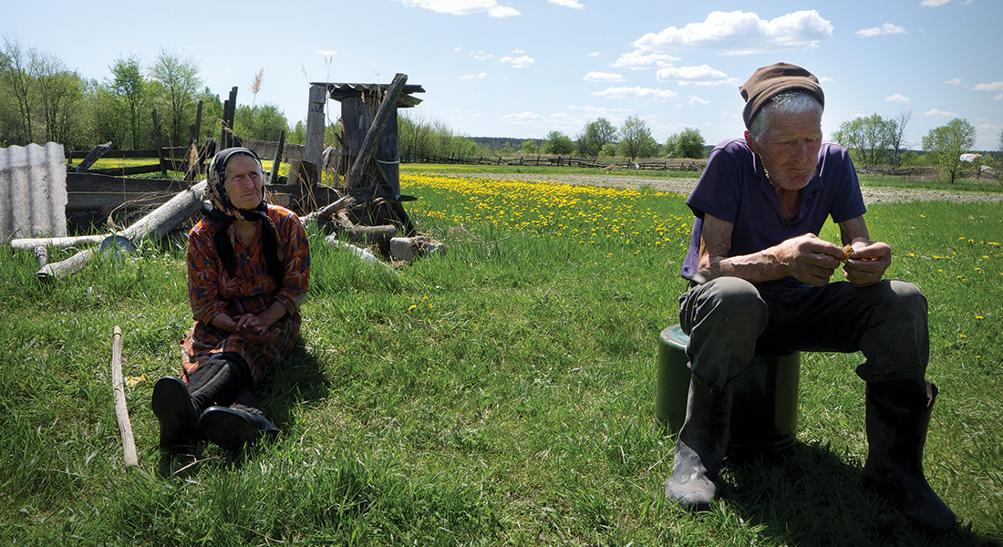 Two people sit alone in a field