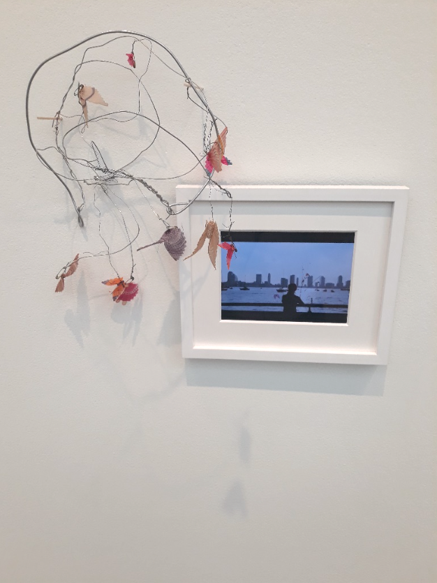 Image of a Precario sculpture made by artist Cecilia Vicuña from found objects including a small frame with a picture inside. Work is on view at the Wexner Center for the Arts in the exhibition Cecilia Vicuña: Lo Precario/The Precarious