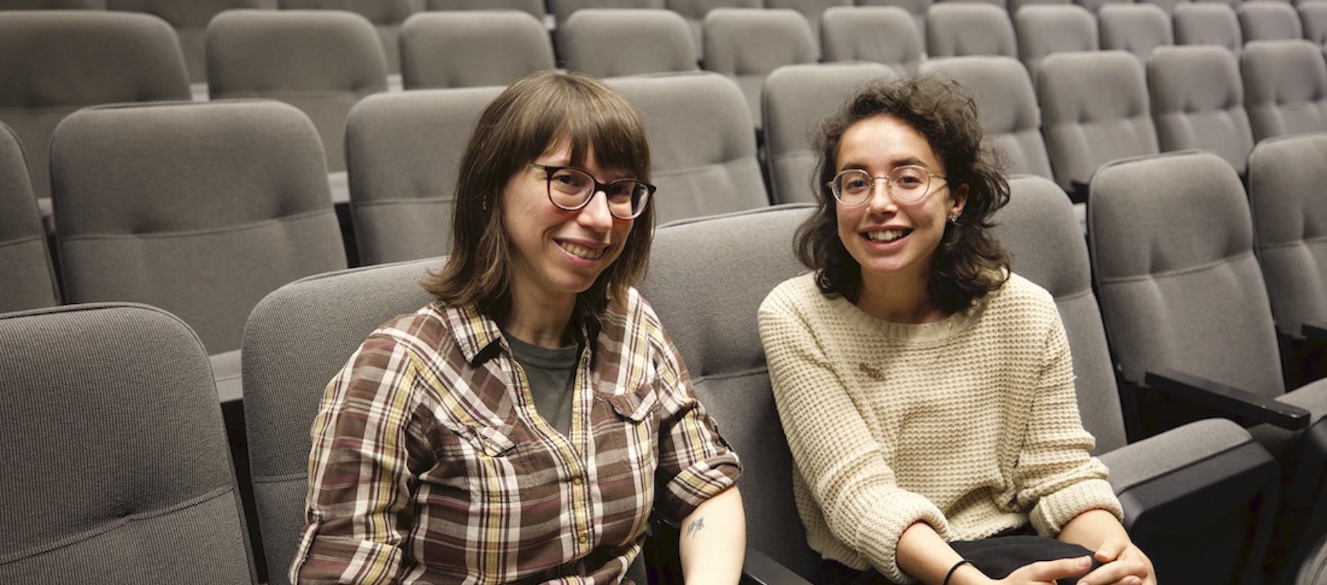 Wexner Center for the Arts projectionist Rachael Barbash and Film/Video program assistant Layla Muchnik-Benali sitting in an otherwise empty screening room
