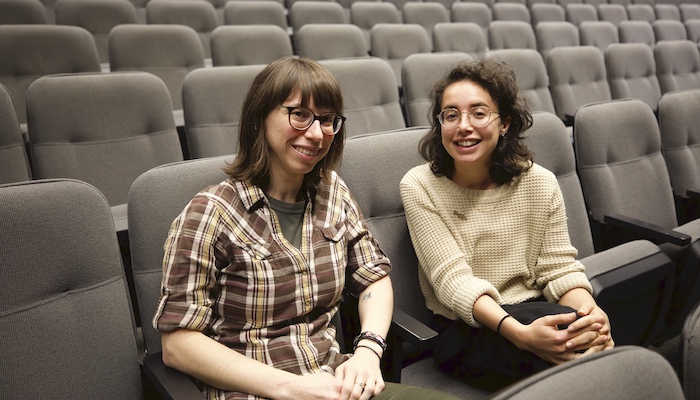 Wexner Center for the Arts projectionist Rachael Barbash and Film/Video program assistant Layla Muchnik-Benali sitting in an otherwise empty screening room