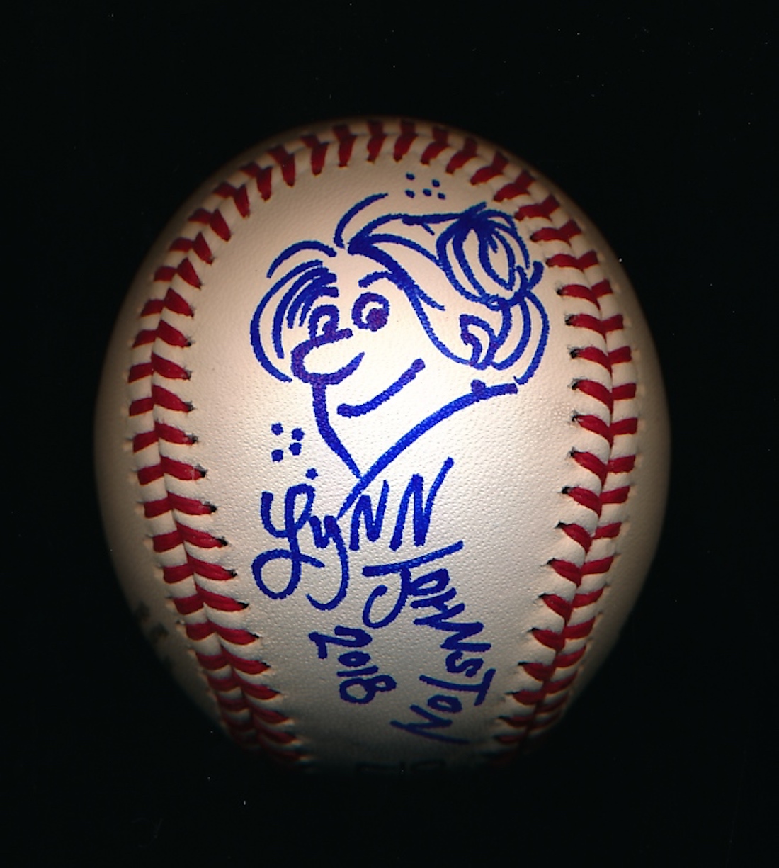 A scanned image of a baseball autographed with illustration by For Better or For Worse cartoonist Lynn Johnston, from the collection of projectionist Bruce Bartoo