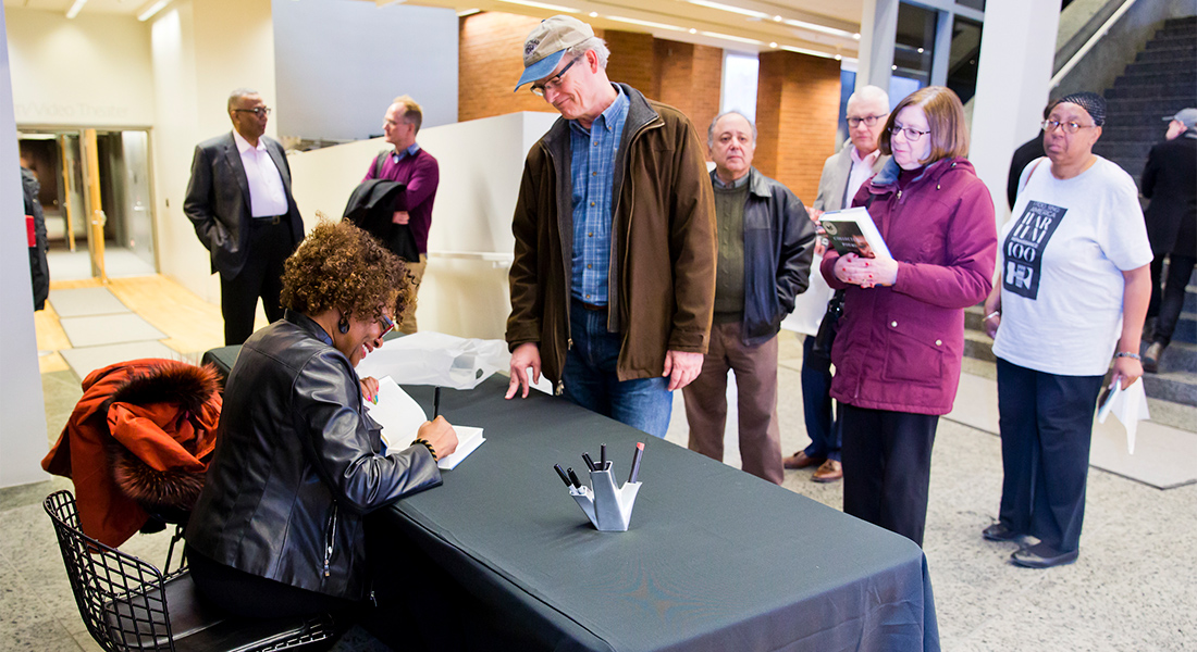An author signs books in front of the Wexner Center Store