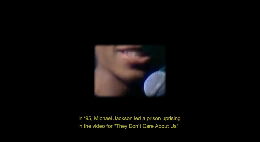 The chin of a black man with a microphone is seen in a small frame surrounded by black with the subtitle, "In '95, led a prison uprising in the video for 'They Don't Care About Us"