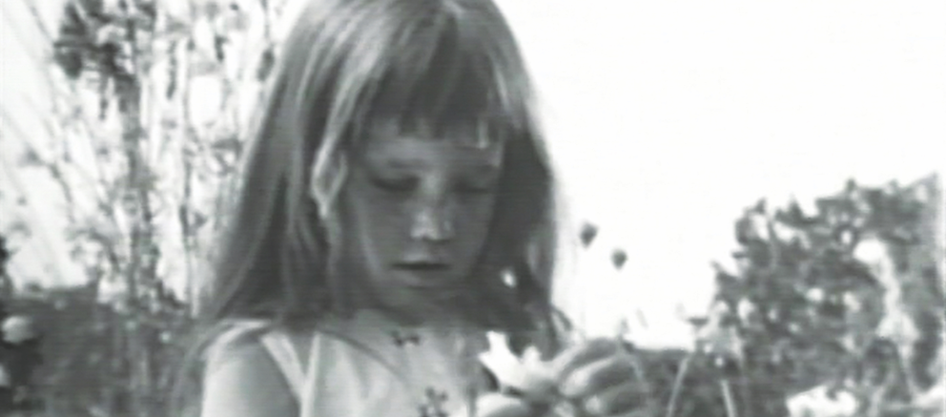 black and white image of a little girl picking the petals off a daisy, from a historic Lyndon Johnson campaign ad