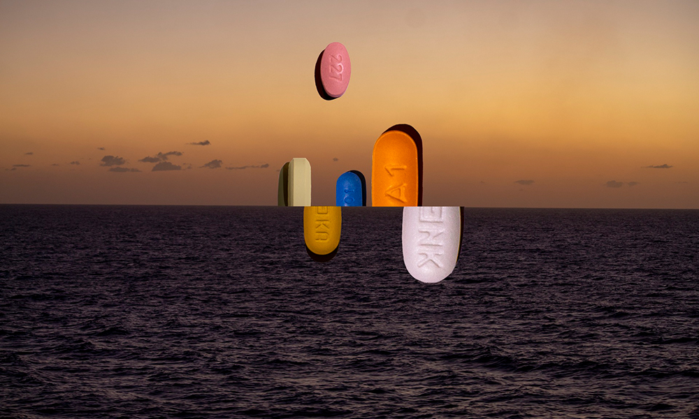 An collage of several pills overlaid on an image of the ocean and a sky at dusk